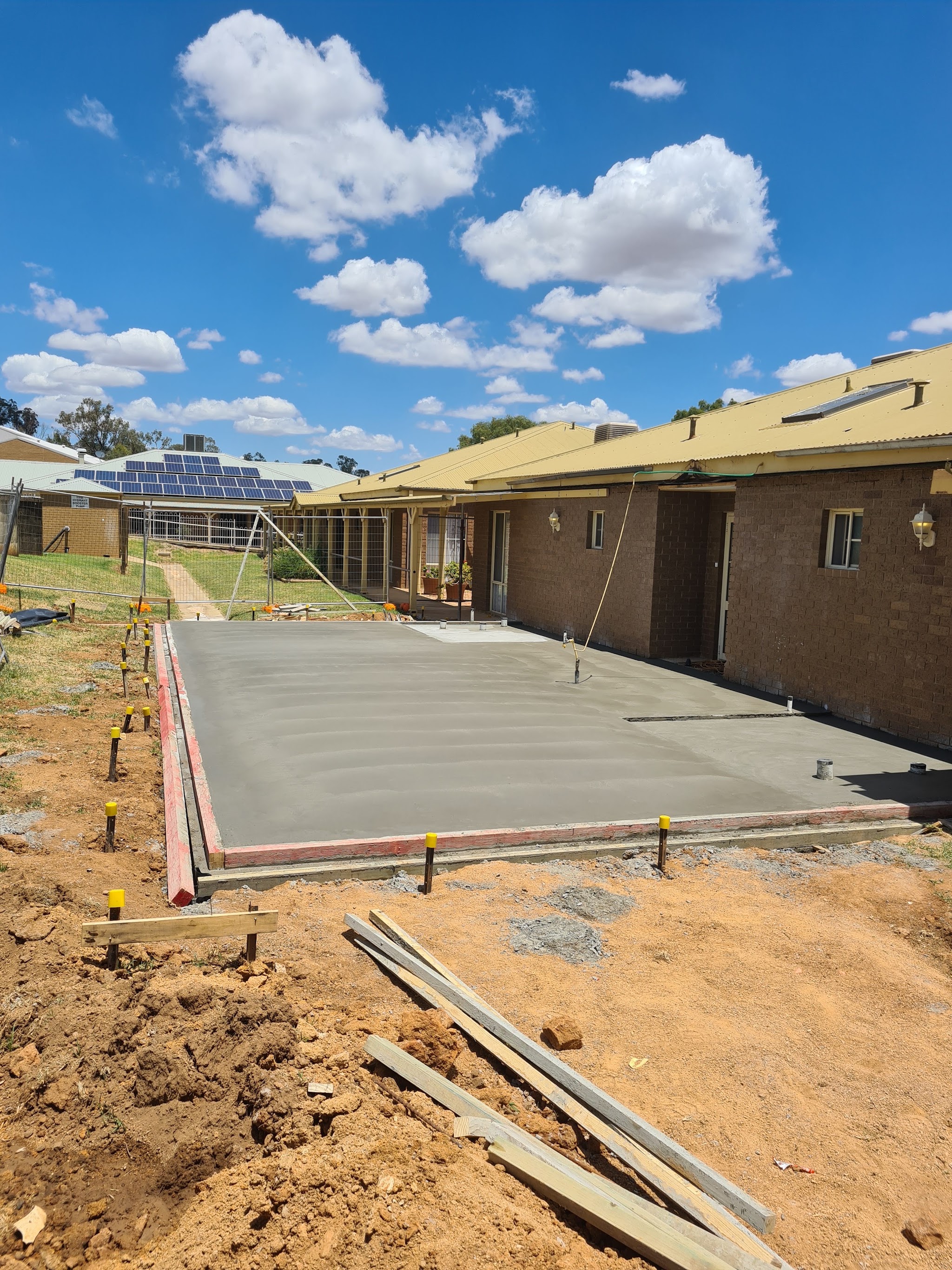 Finished broom-finish slab beside a brick home in Cowra