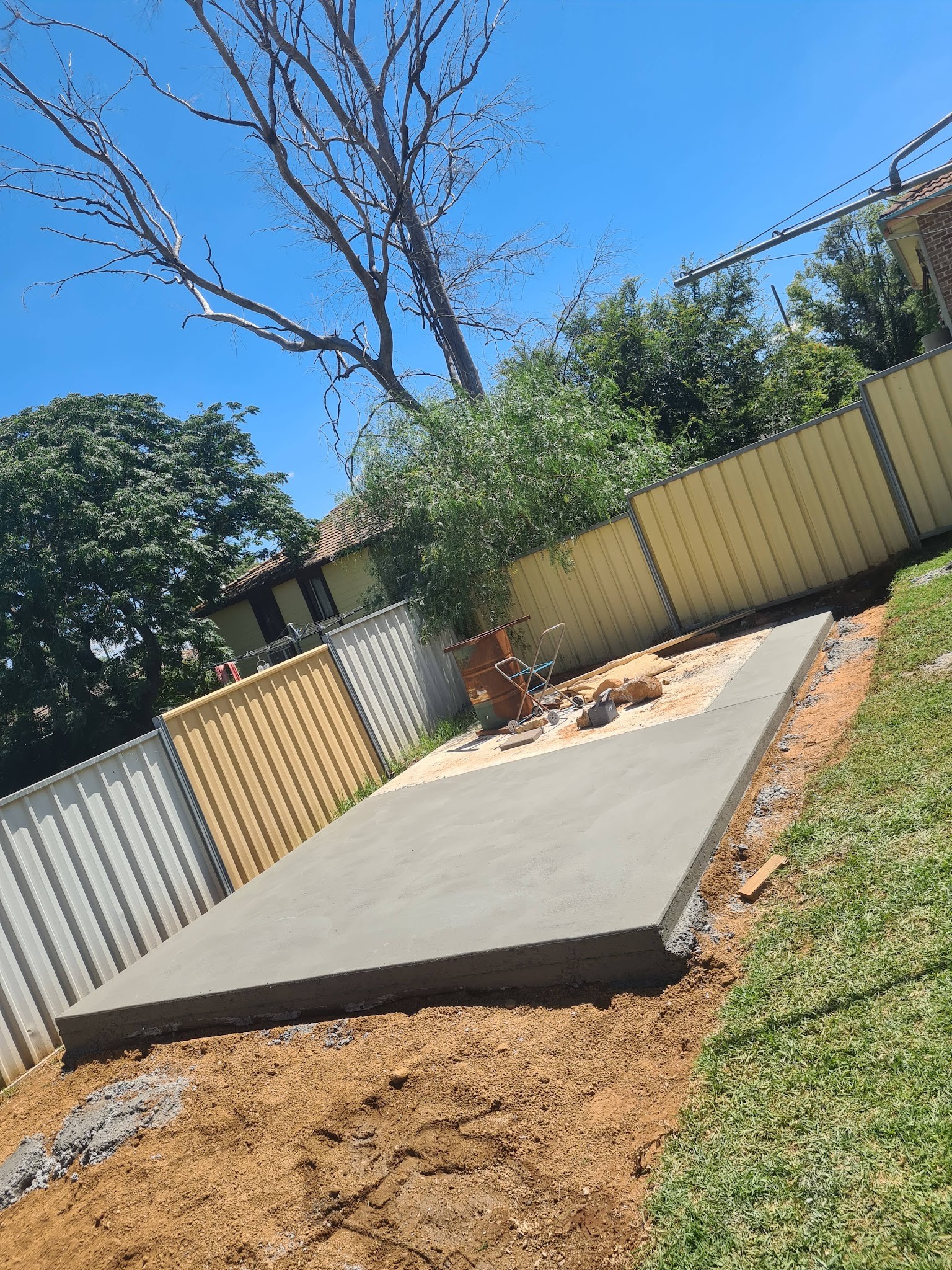 Finished concrete slab beside a colorbond shed